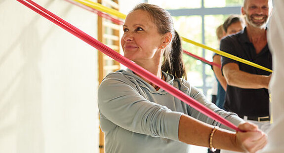 Training mit Terrabändern Mehrere Patienten trainieren mit Terrabändern in der Halle.