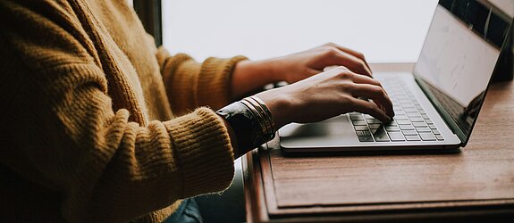 Person tippt etwas auf dem Laptop.