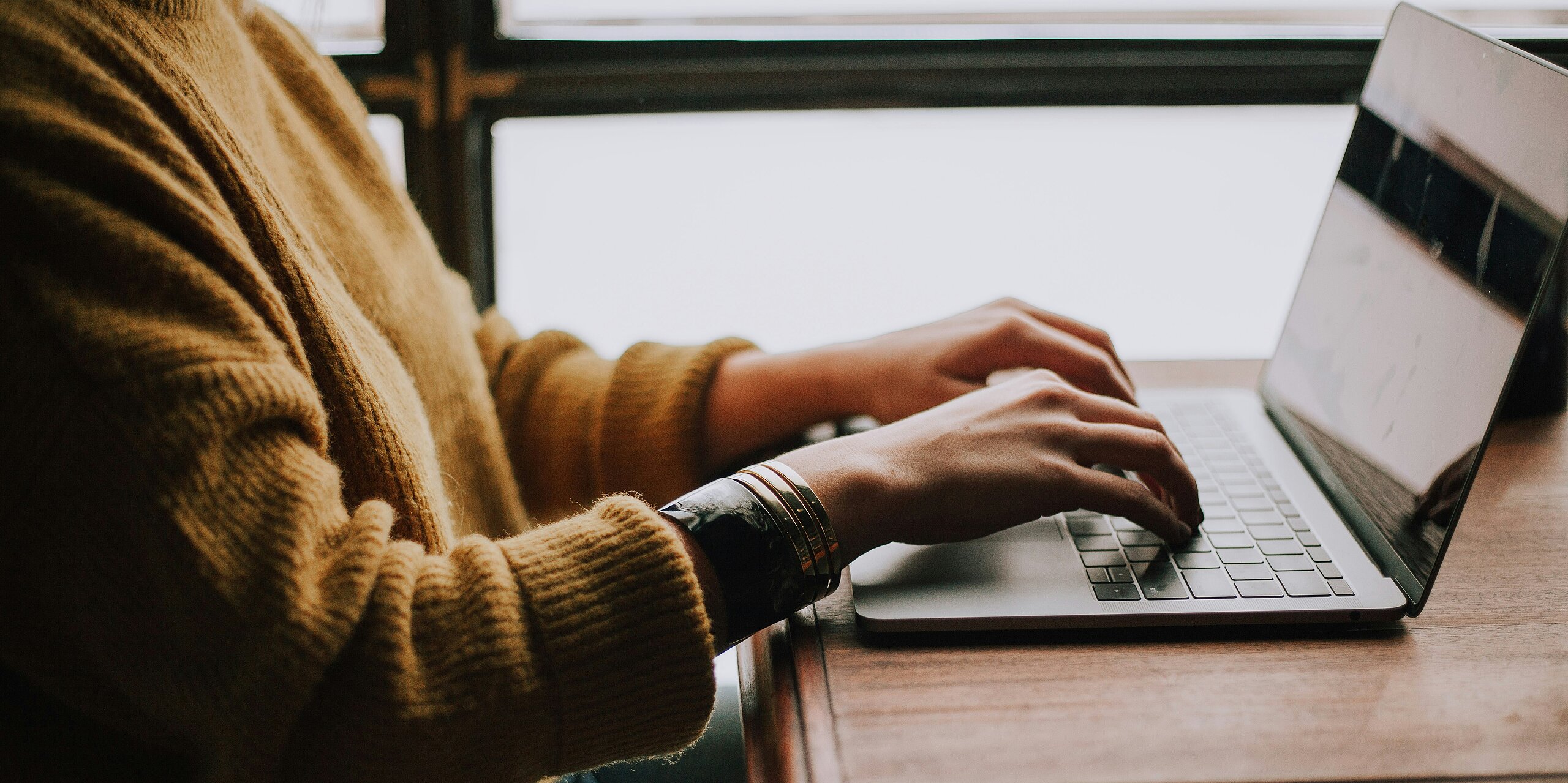 Person tippt etwas auf dem Laptop.