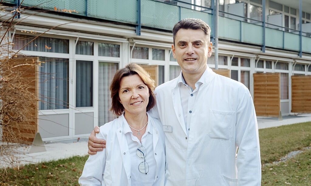 Ein Ärzteehepaar steht vor der Rehaklinik.