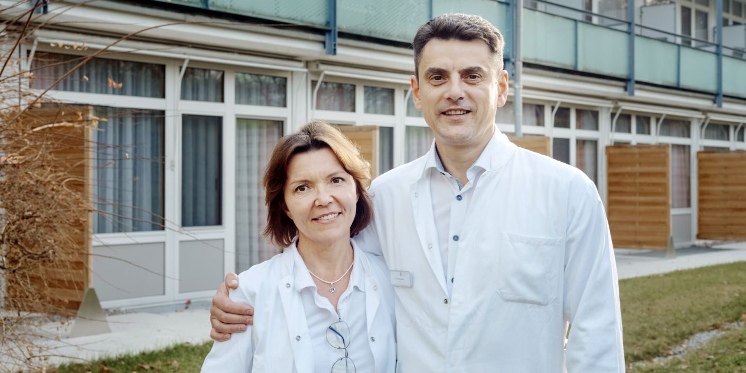 Ein Ärzteehepaar steht vor der Rehaklinik.