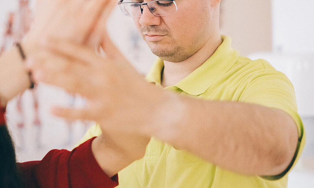 Blinder Physiotherapeut bei der Behandlung.
