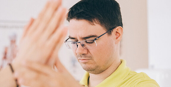 Blinder Physiotherapeut bei der Behandlung.