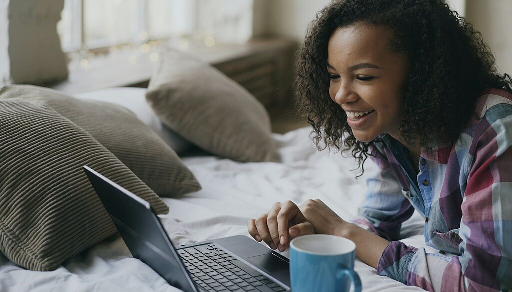 Eine Frau schaut in den Laptop.
