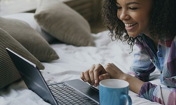 Eine Frau schaut in den Laptop.