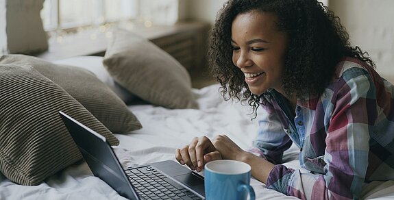 Eine Frau schaut in den Laptop.