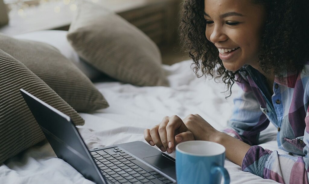 Eine Frau schaut in den Laptop.