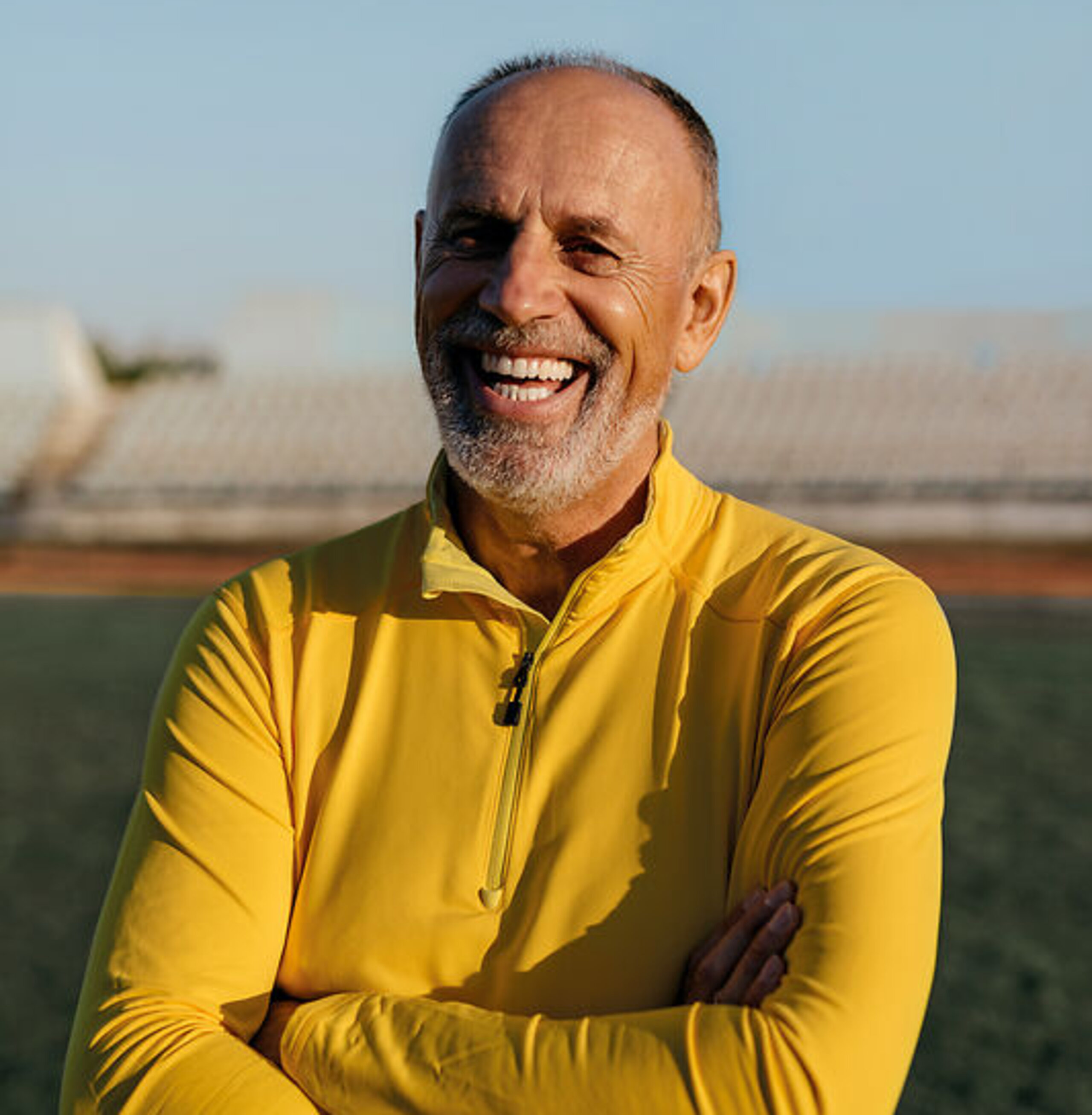 Mann lachend Ein Mann im Rentenalter lacht freundlich im Fußballstadion.
