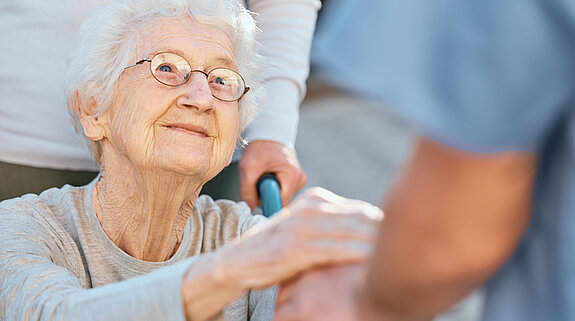 Seniorin Hände Eine Seniorin im Rollstuhl hält dankbar die Hände einer Pflegekraft.