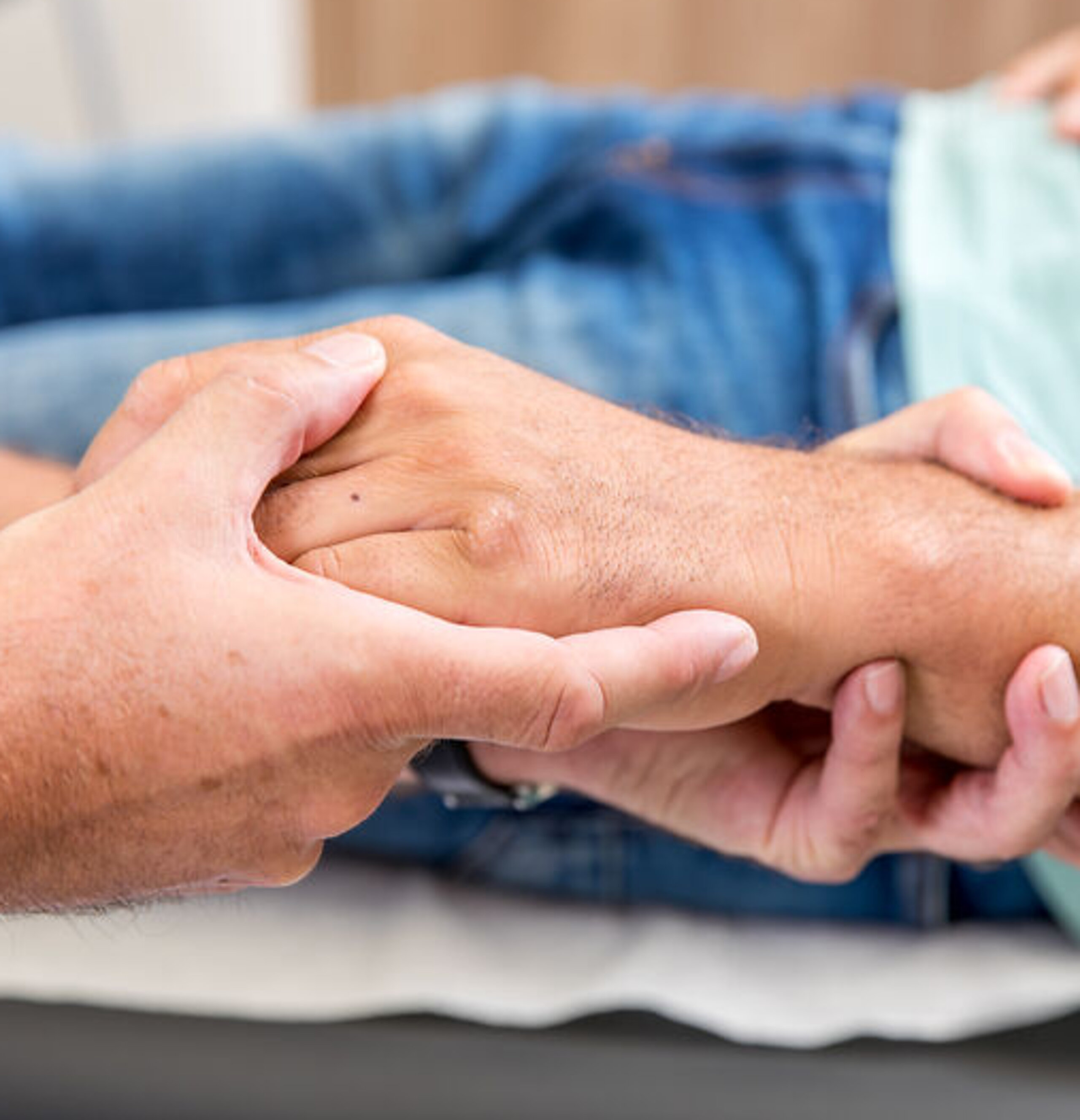 Hände Untersuchung Ein Arzt umfasst die Hand eines Patienten.
