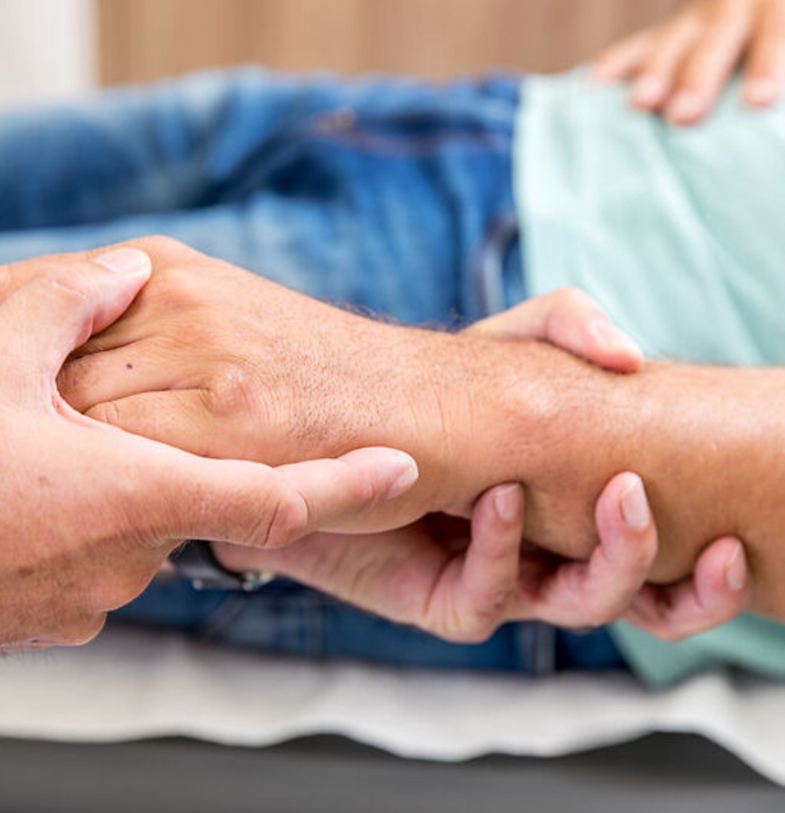 Hände Untersuchung Ein Arzt umfasst die Hand eines Patienten.