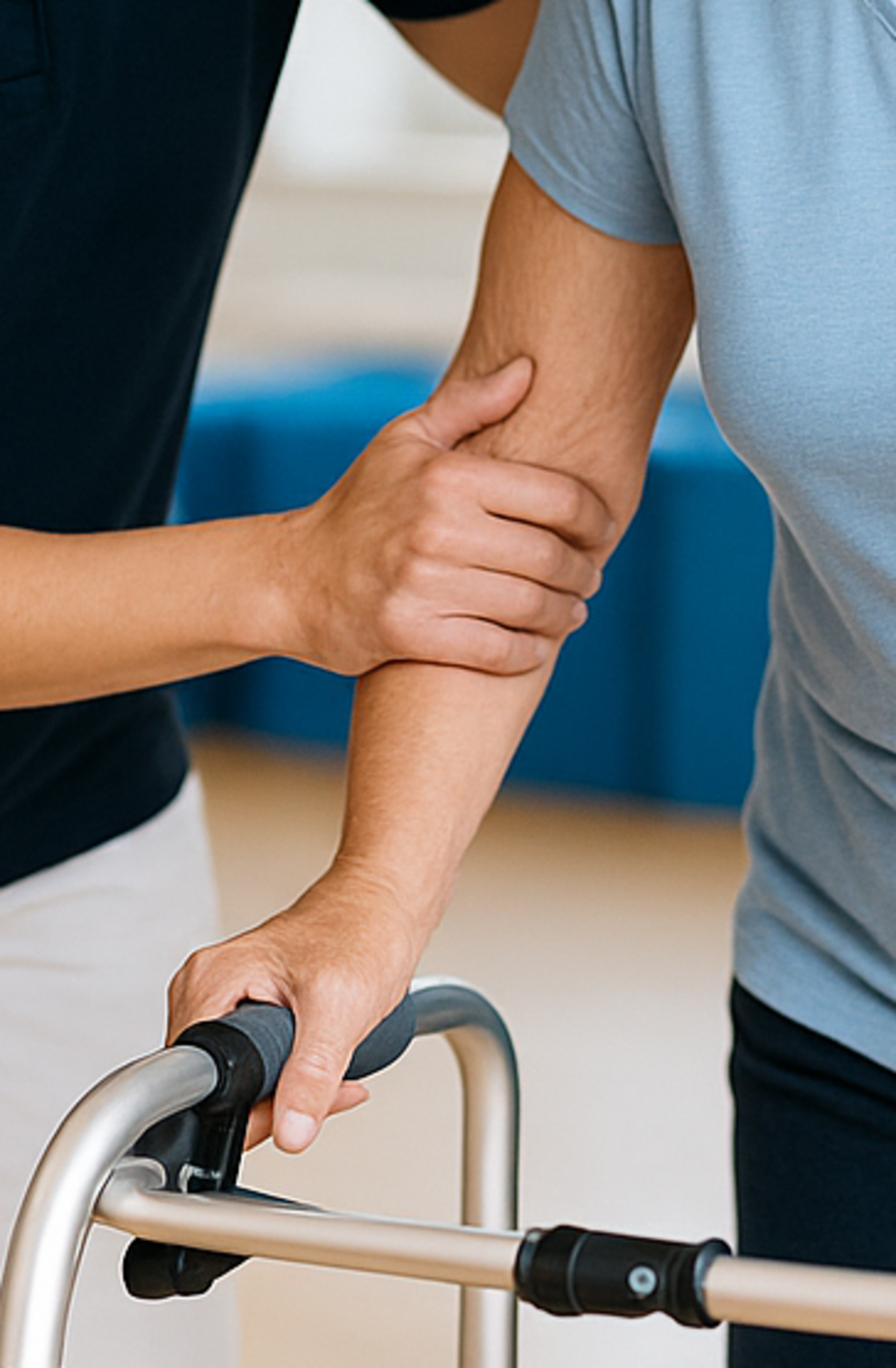 Gangtraining Eine Therapeutin unterstützt eine Patientin beim Gangtraining mit Gehhilfe.