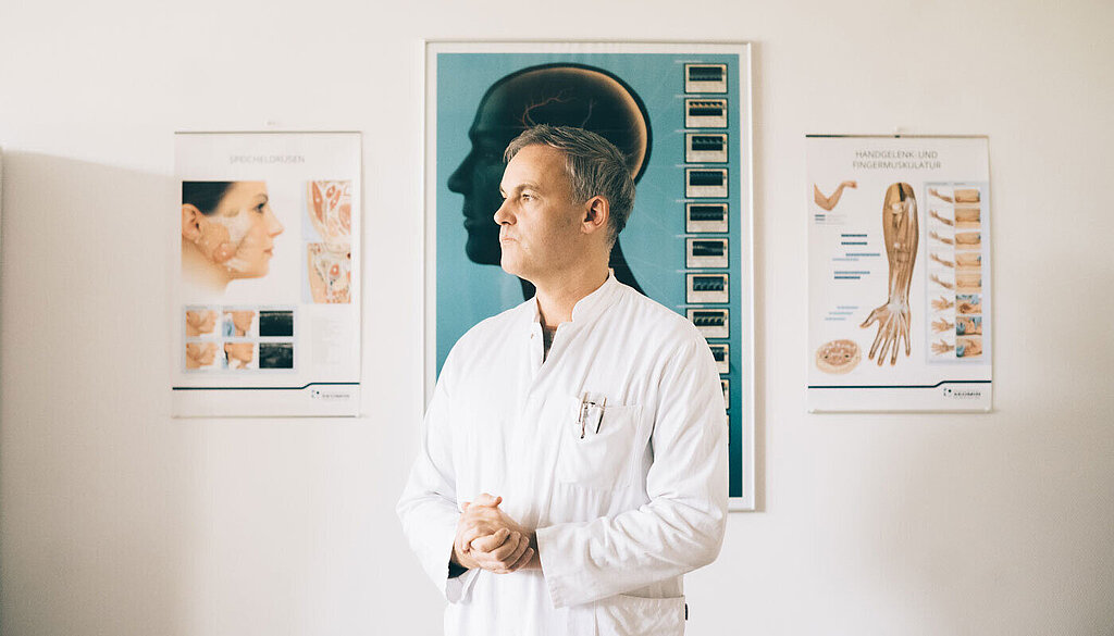 Dr. Dr. Markus Schlomm steht in seinem Behandlungszimmer.