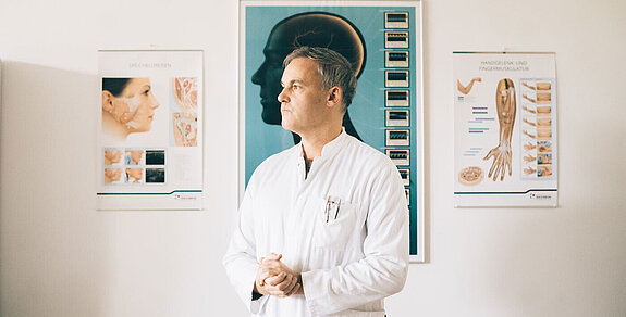 Dr. Dr. Markus Schlomm steht in seinem Behandlungszimmer.