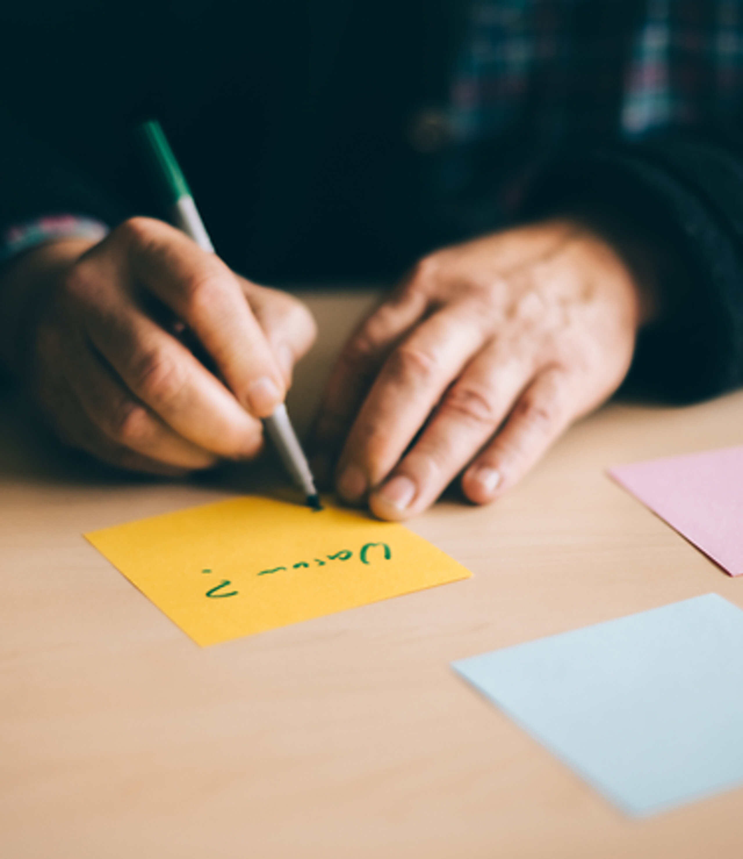 Eine Person schreibt Notizzettel.