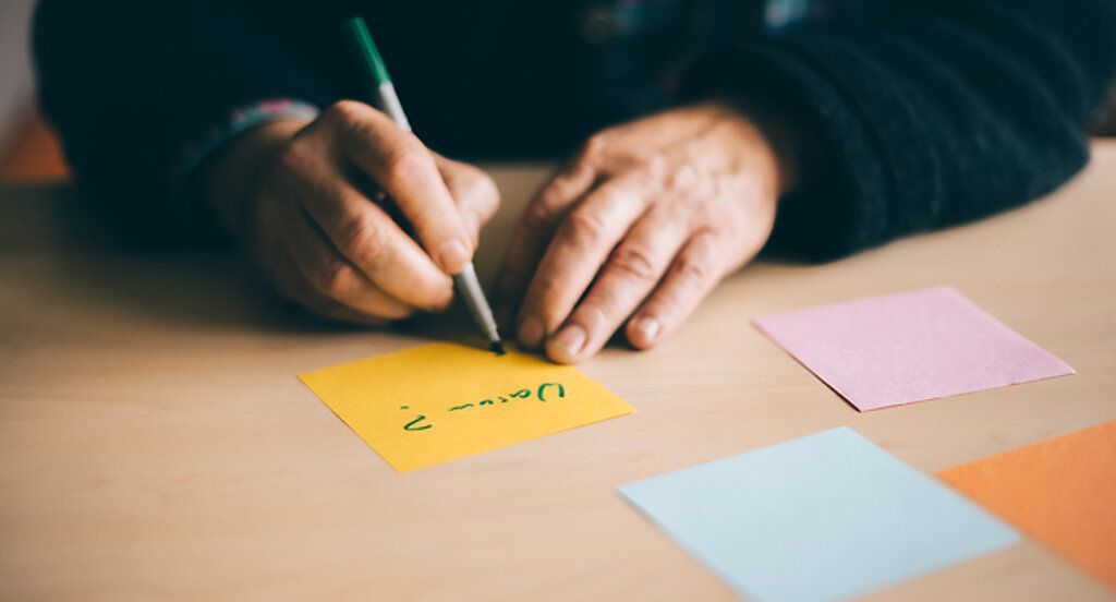 Eine Person schreibt Notizzettel.