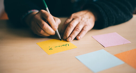 Eine Person schreibt Notizzettel.