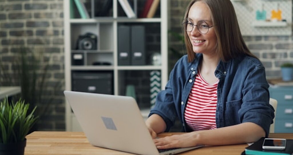 Laptop Frau am Laptop lächelnd.