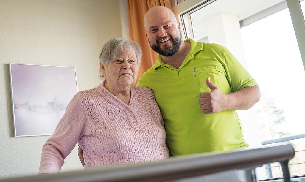 Ursel Kaiser mit Therapeut am Gehbarren.