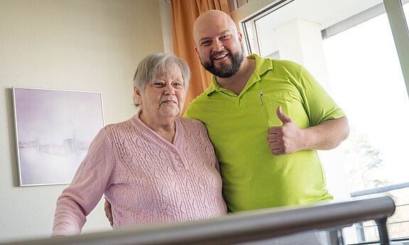 Ursel Kaiser mit Therapeut am Gehbarren.