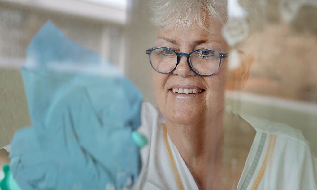 Petra Weber putzt ein Fenster.