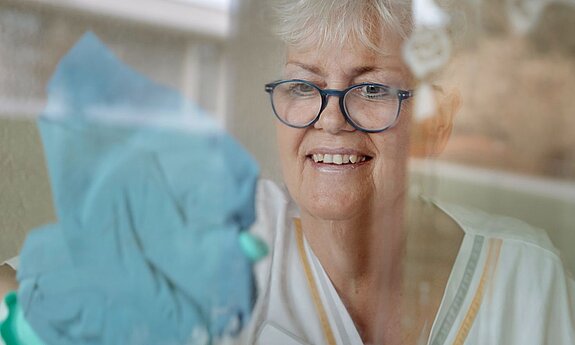 Petra Weber putzt ein Fenster.