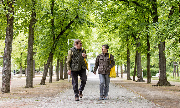 Ein Rehabilitand und eine Rehabilitandin gehen im Kurpark Bad Salzelmen spazieren.