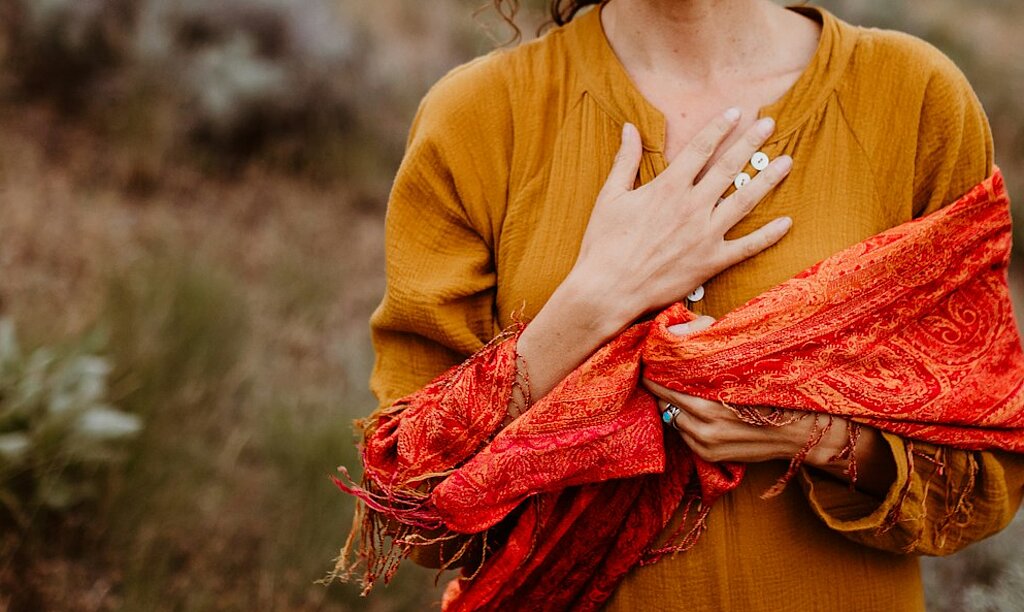 Eine Frau atmet tief ein in der Natur.