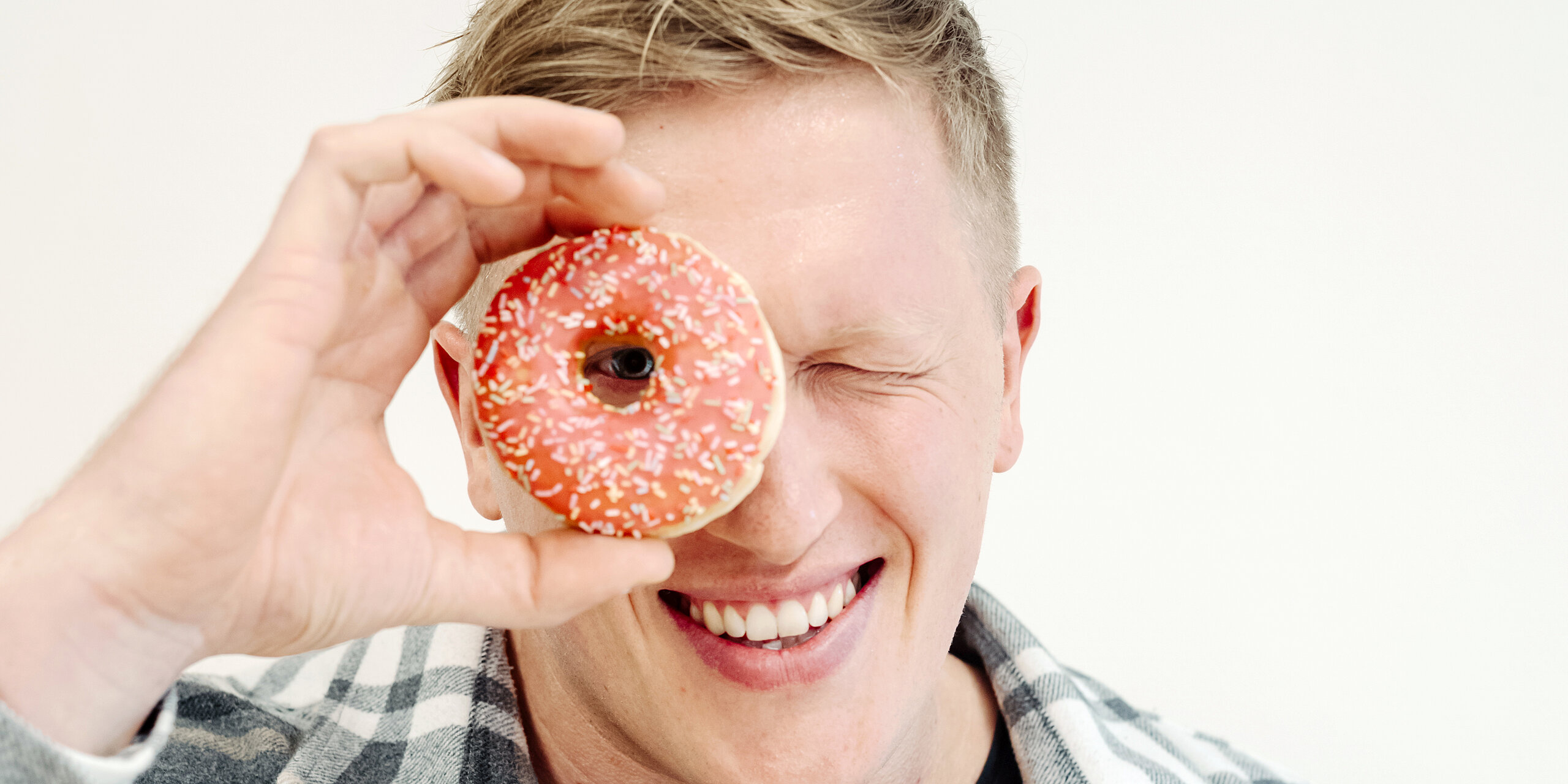 Jan Blaschko sieht mit einem Auge durch einen Donut.