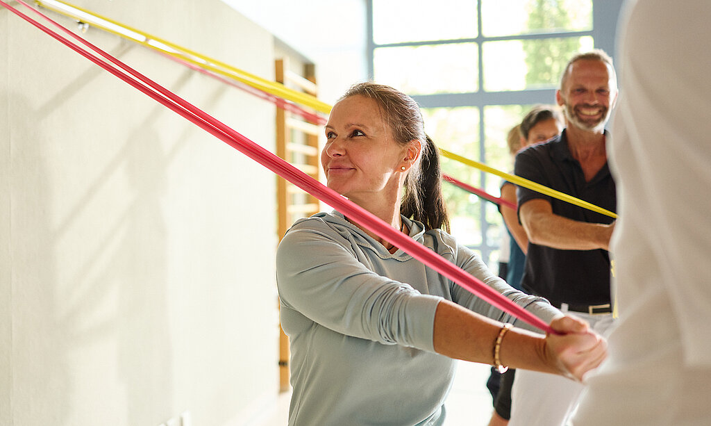 Eine Gruppe übt mit Terrabändern in der Halle.