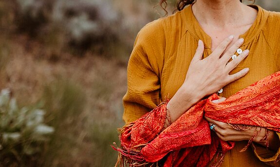 Eine Frau atmet tief ein in der Natur.
