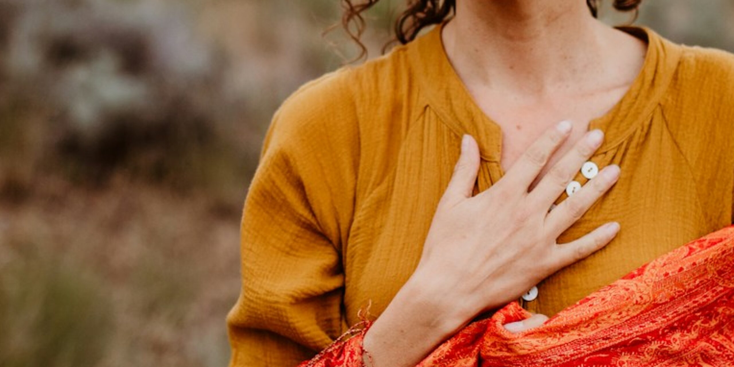 Eine Frau atmet tief ein in der Natur.