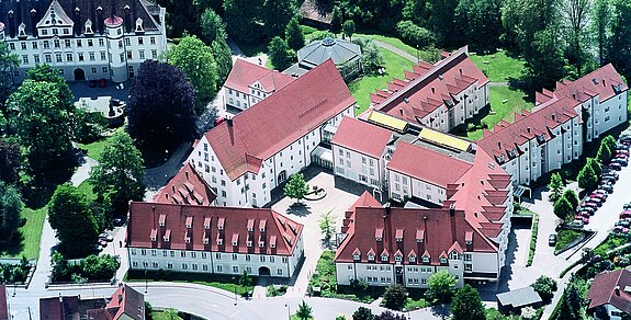 Luftaufnahme der Klinik im Hofgarten in Bad Waldsee, umgeben von grüner Natur und roten Dächern