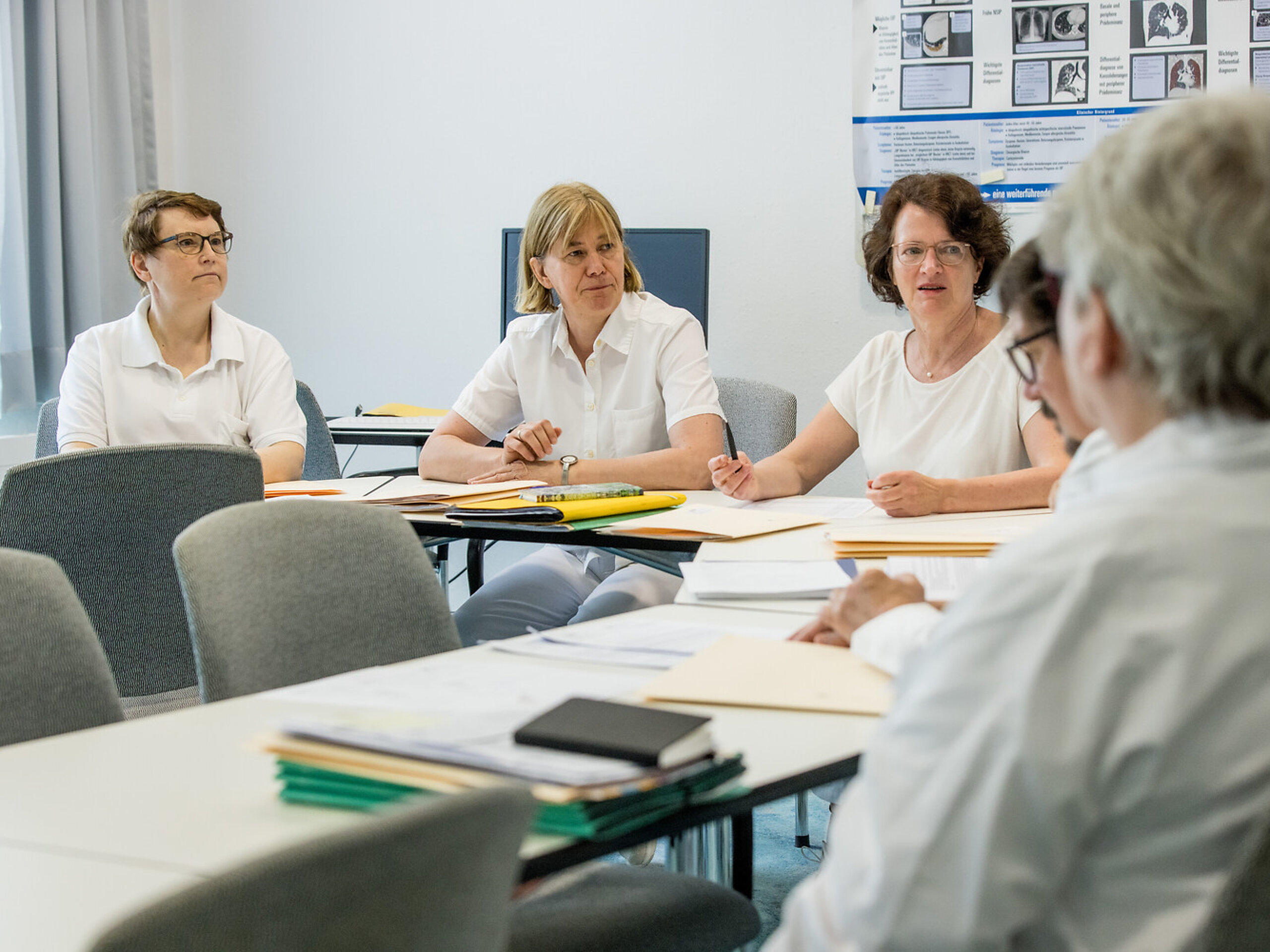 Eine Gruppe medizinischer Angestellter bespricht sich.