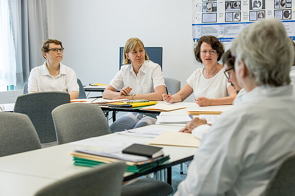 Eine Gruppe medizinischer Angestellter bespricht sich.