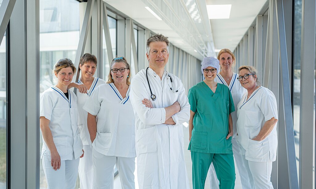 In der Mitte OA Dr. Neumann und jeweils links und rechts stehen die Pflegefachkräfte