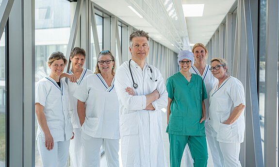 In der Mitte OA Dr. Neumann und jeweils links und rechts stehen die Pflegefachkräfte