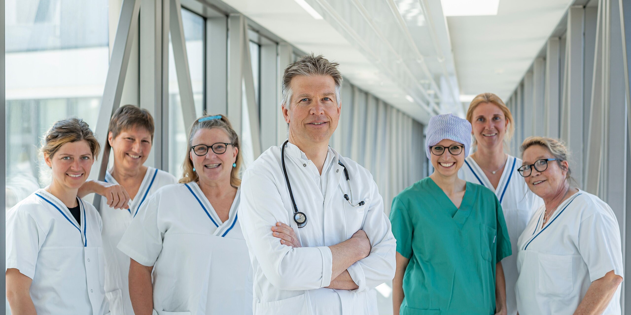 In der Mitte OA Dr. Neumann und jeweils links und rechts stehen die Pflegefachkräfte