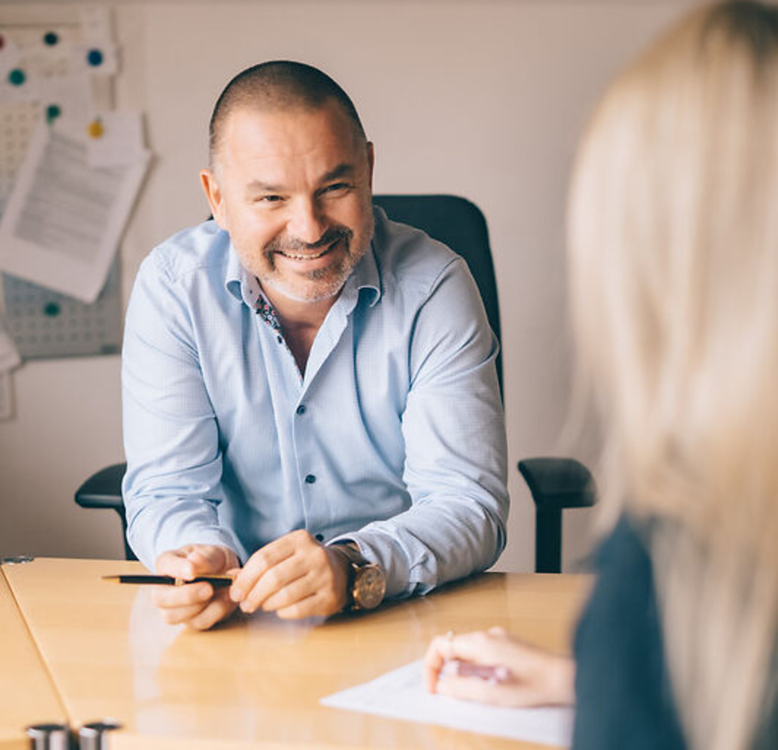 Dr. Köhler berät freundlich eine Patientin am Schreibtisch.