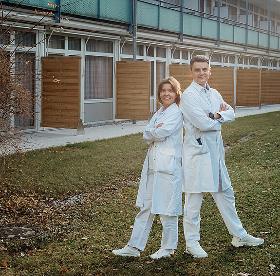 Ein Ärzteehepaar steht vor der Rehaklinik.