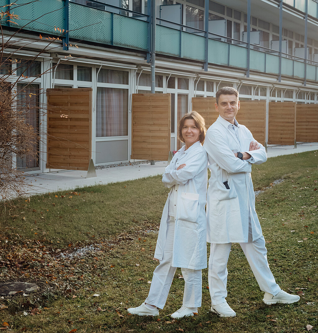 Ein Ärzteehepaar steht vor der Rehaklinik.