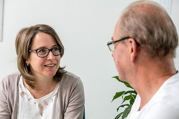 Sozialdienst Eine Sozialarbeiterin führt ein Gespräch mit einem Mann