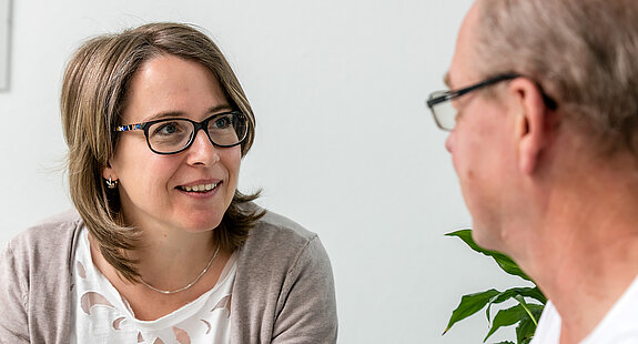 Eine Sozialarbeiterin führt ein Gespräch mit einem Mann