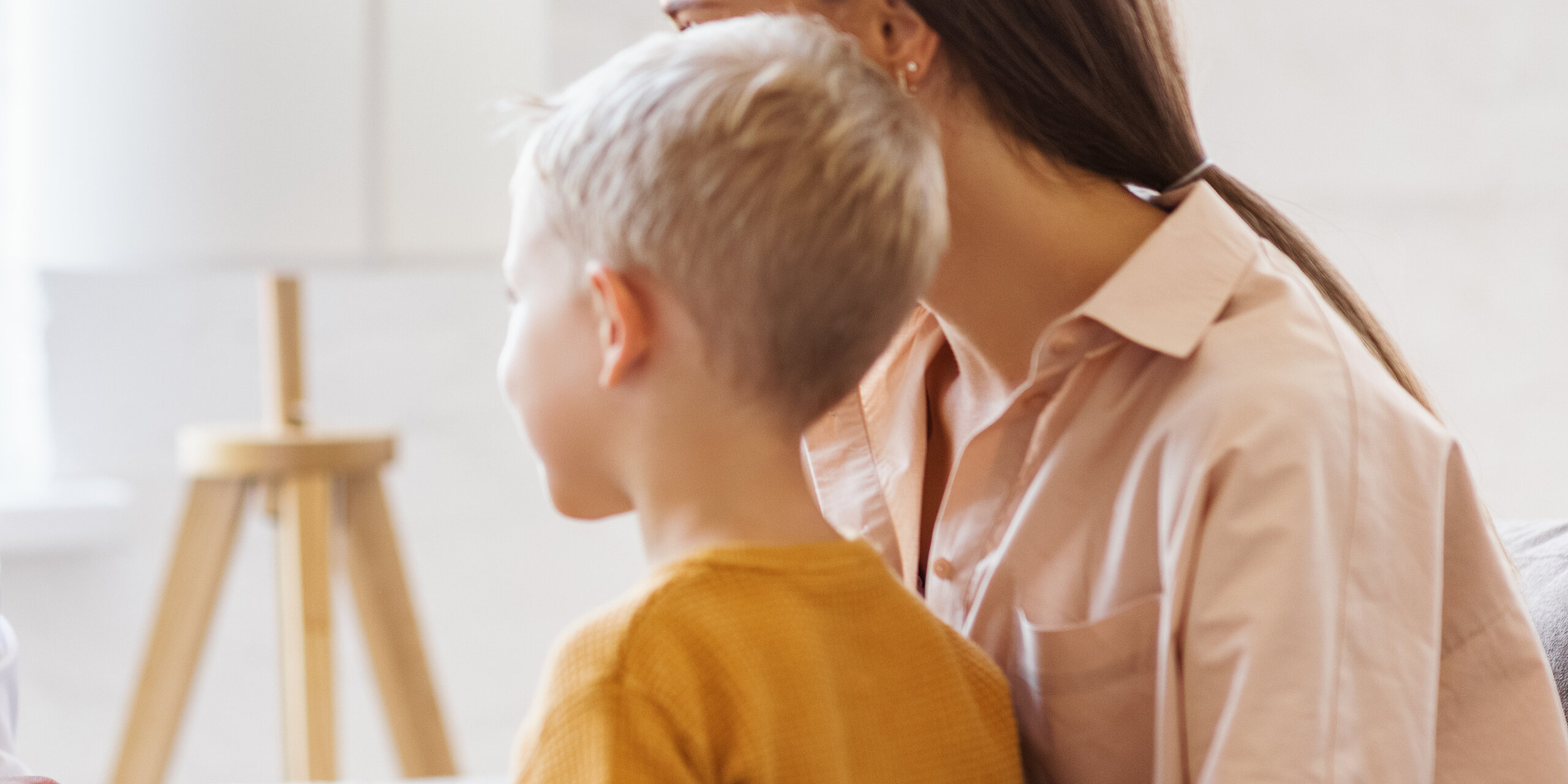 Ein freundlicher Arzt berät eine Mutter mit Sohn.