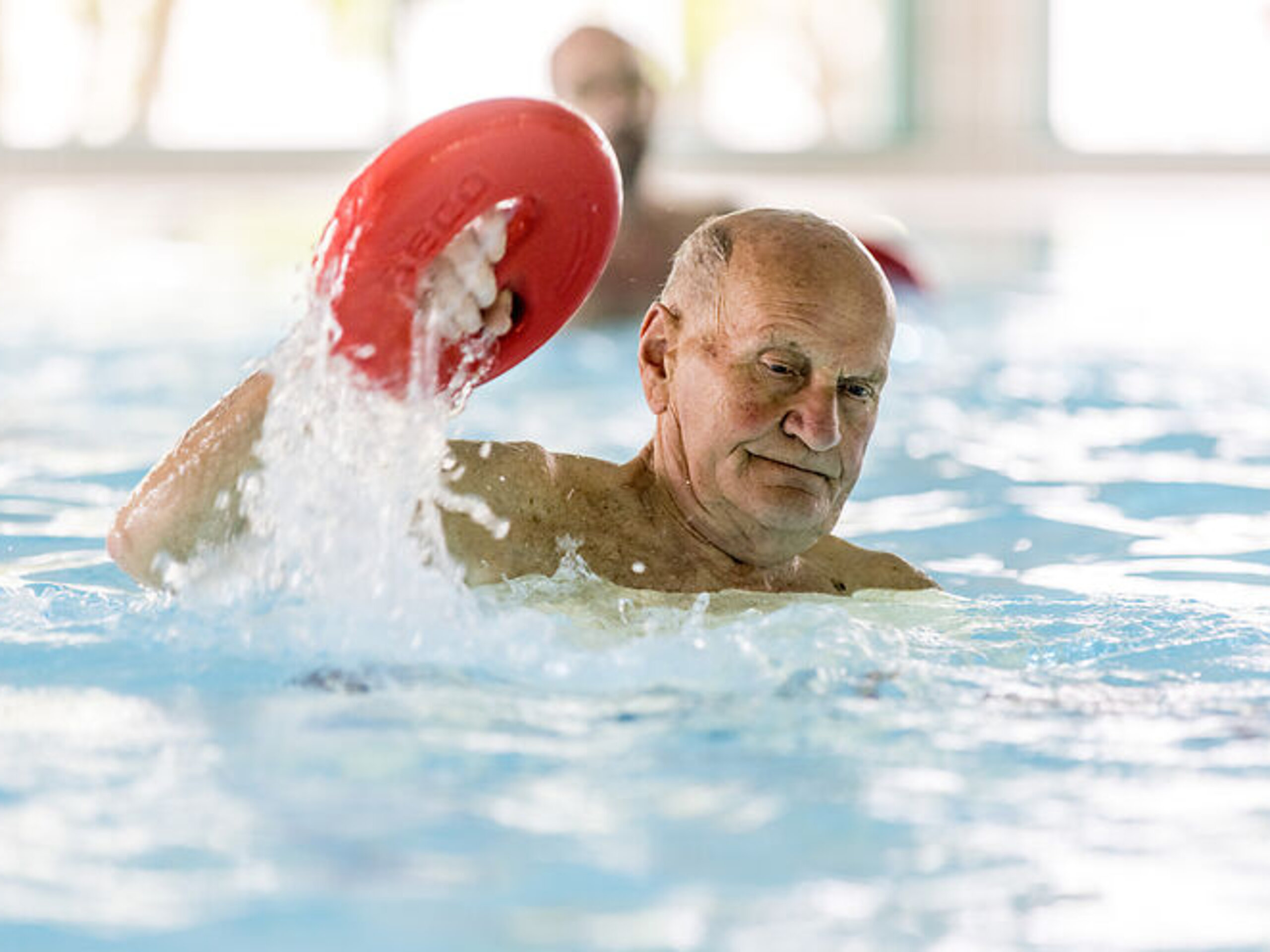 Ein Mann trainiert im Wasser mit einem Utensil.