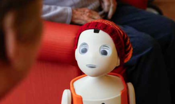 Pflegeroboter Oscar redet mit einer Seniorin.