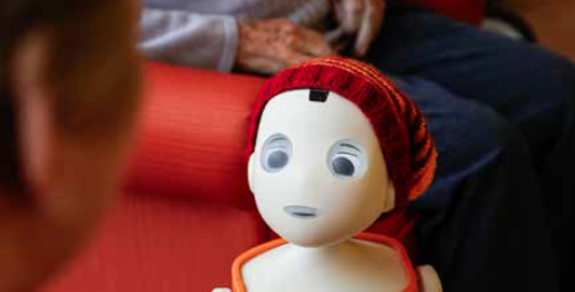 Pflegeroboter Oscar redet mit einer Seniorin.