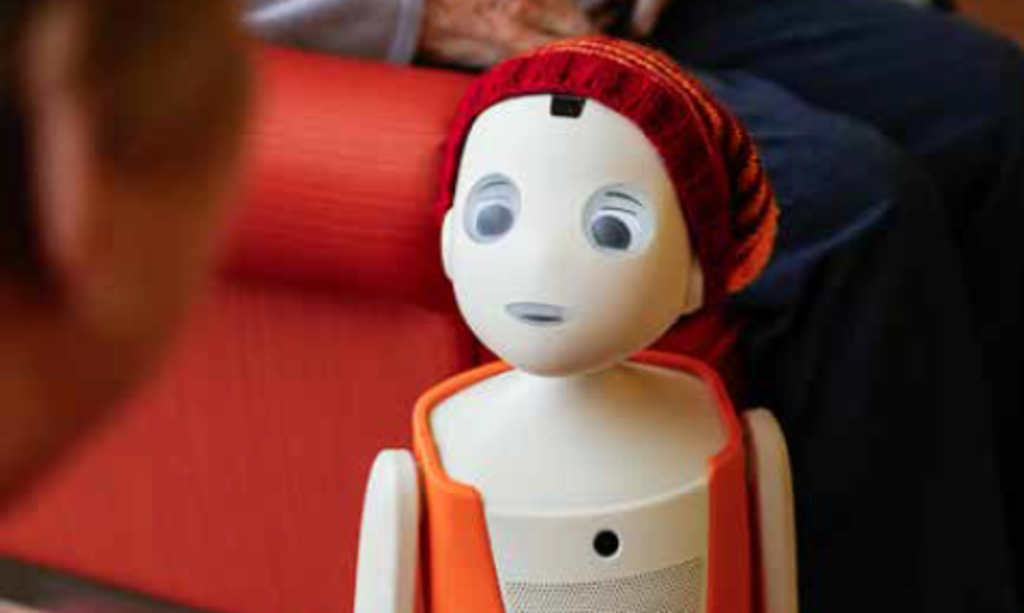 Pflegeroboter Oscar redet mit einer Seniorin.