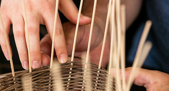 Korbflechten Ergotherapie Eine Patientin flechtet einen Korb in der Ergotherapie