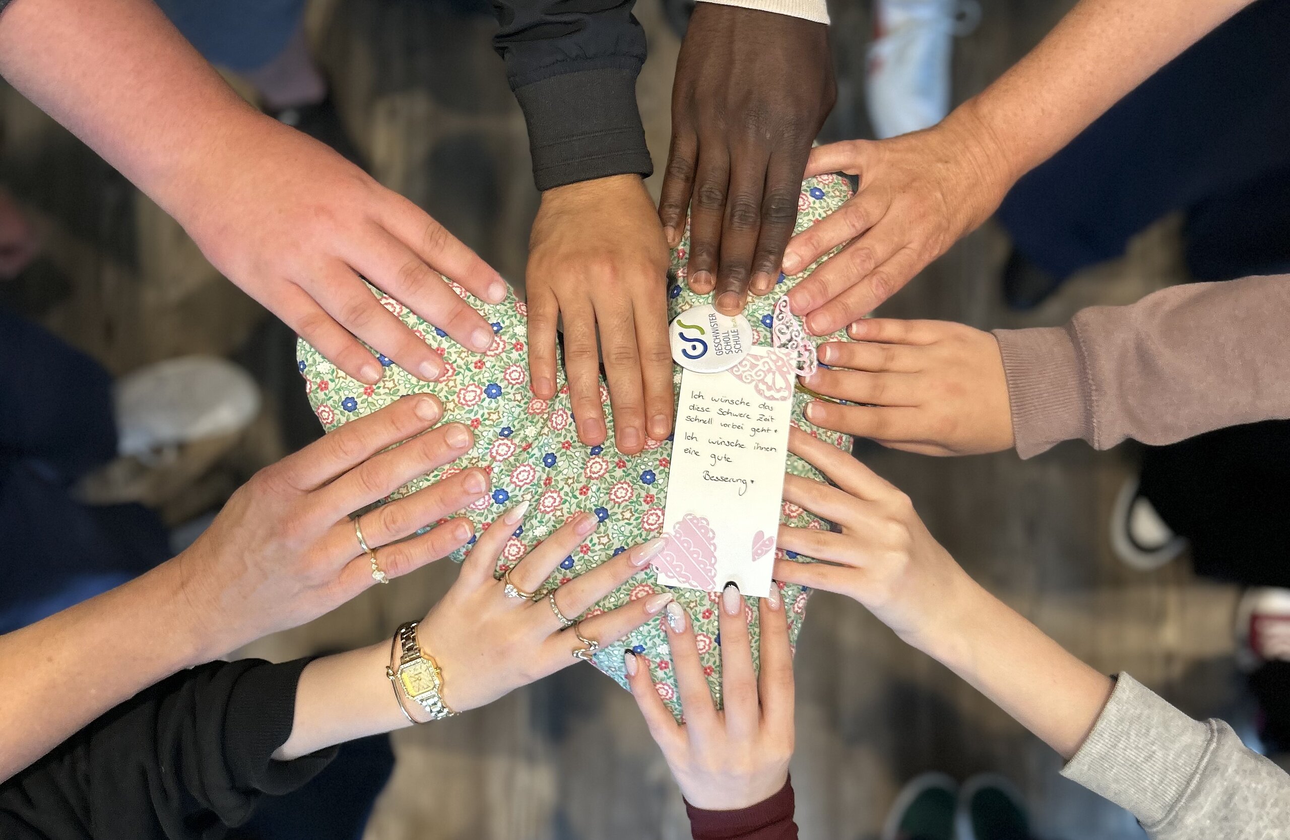 Selbst genähtes Kissen wird von vielen Händen gehalten